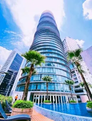 a tall building with palm trees in front of it at Vortex KLCC by Family Suites in Kuala Lumpur