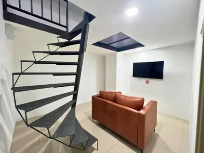 a spiral staircase in a living room with a couch at Seeds Hotel Premier Chow Kit Kuala Lumpur in Kuala Lumpur