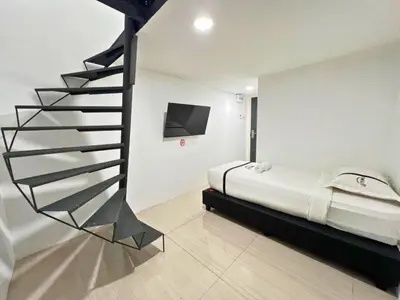 a bedroom with a spiral staircase next to a bed at Seeds Hotel Premier Chow Kit Kuala Lumpur in Kuala Lumpur