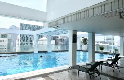 a large swimming pool in a building with chairs at Parkview 2bedroom apartment klcc in Kuala Lumpur