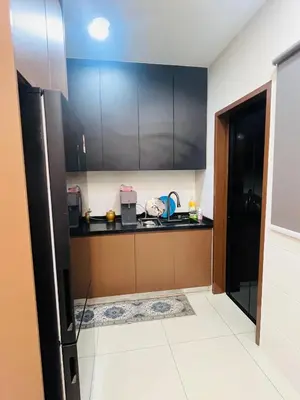 a kitchen with black cabinets and a counter top at Vista Sentul Residence in Kuala Lumpur