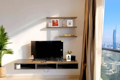 a living room with a flat screen tv on a table at Trion KL Service Suite - Modern City Stay with Pool & Gym in Kuala Lumpur
