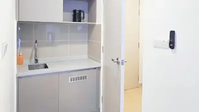 a kitchen with white cabinets and a sink at Trion KL Service Suite - Modern City Stay with Pool & Gym in Kuala Lumpur