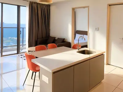 a kitchen and living room with a couch in the background at Trion KL Service Suite - Modern City Stay with Pool & Gym in Kuala Lumpur