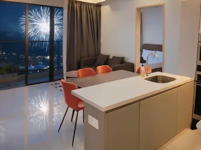 a kitchen and living room with a view of fireworks at Trion KL Service Suite - Modern City Stay with Pool & Gym in Kuala Lumpur