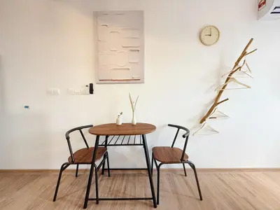 a table and two chairs in a room with a clock at Cozy Studio I Riveria City I 1km to KL Sentral in Kuala Lumpur