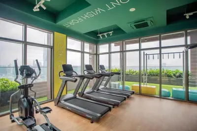 a gym with treadmills and ellipticals in a room with windows at Cozy Studio I Riveria City I 1km to KL Sentral in Kuala Lumpur