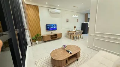 a living room with a table and a tv at Majestic Alaman Suites KLCC in Kuala Lumpur