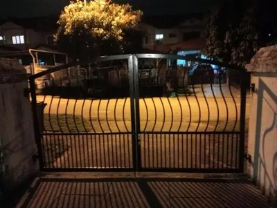 a gate to a parking lot at night at have fun staying here in Kuala Lumpur