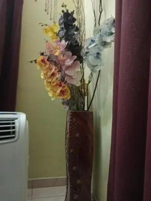 a vase filled with flowers sitting next to a wall at have fun staying here in Kuala Lumpur