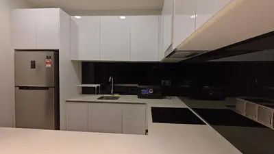 a kitchen with white cabinets and a stainless steel refrigerator at Star Residence KLCC By LLKOK in Kuala Lumpur