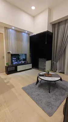 a living room with a table and a tv at Star Residence KLCC By LLKOK in Kuala Lumpur