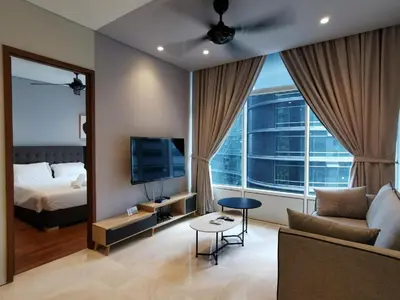 a living room with a couch and a tv and a bed at Sky Suites in Kuala Lumpur