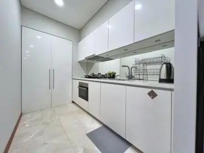a kitchen with white cabinets and a stove at Sky Suites in Kuala Lumpur
