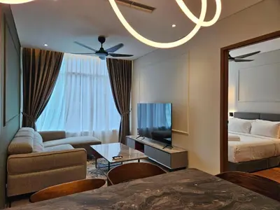 a living room with a bed and a couch and a tv at Sky Suites in Kuala Lumpur