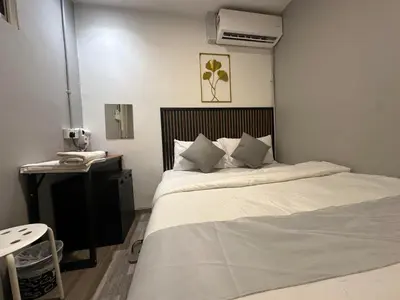 a bedroom with a bed and a desk with a phone at SS Grey House Bukit Bintang in Kuala Lumpur