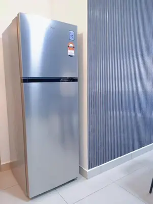 a stainless steel refrigerator in a room next to a wall at M VERTICA Isyak Homestay in Kuala Lumpur