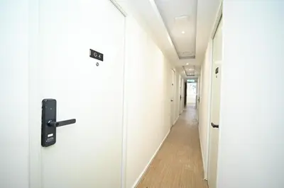 a corridor of an office with white walls and wooden floors at Swing & Pillows - Sungei Wang Bukit Bintang in Kuala Lumpur