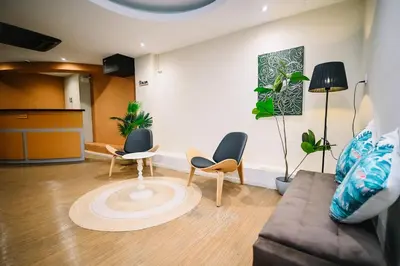 a living room with two chairs and a couch at Swing & Pillows - Sungei Wang Bukit Bintang in Kuala Lumpur