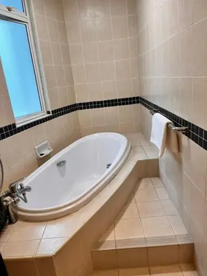a white tub in a bathroom with a window at Seri Bukit Ceylon Bukit Bintang in Kuala Lumpur