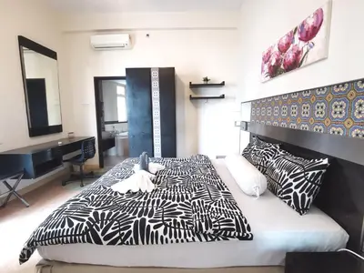 a bedroom with a black and white bed with pillows at Seri Bukit Ceylon Bukit Bintang in Kuala Lumpur