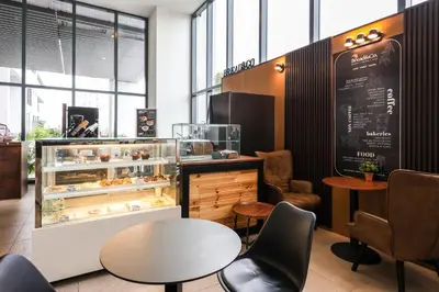 a bakery with a table and chairs and a display case at Heaven Suites KL in Kuala Lumpur