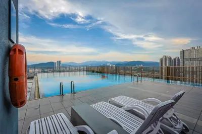 a balcony with a swimming pool on top of a building at Heaven Suites KL in Kuala Lumpur