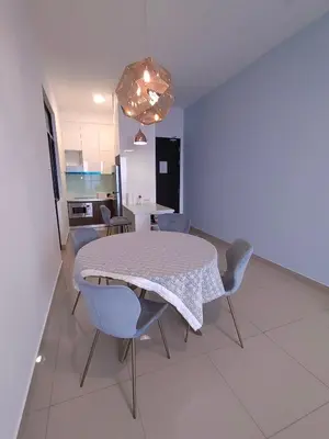 a dining room with a table and chairs and a kitchen at Service Apartment Sunway Velocity in Kuala Lumpur