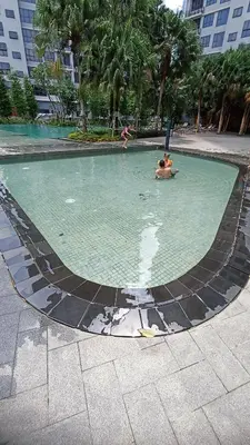 a pool of water with two people in it at Agile Milestone service suite TRX by KL in Kuala Lumpur