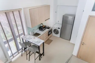 a kitchen with a table and two chairs and a refrigerator at The Colony & Luxe Kuala Lumpur with KLCC View Skypool by COBNB in Kuala Lumpur