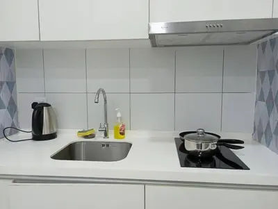 a kitchen counter with a sink and a stove at Chamber suites KLCC by Global stay in Kuala Lumpur