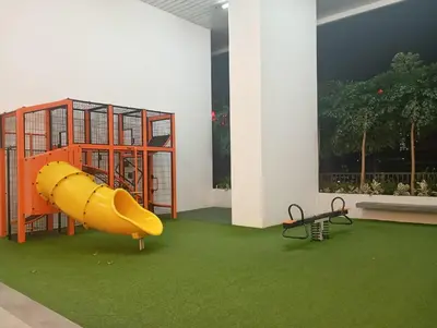 a playground with a yellow slide on a green carpet at Chamber suites KLCC by Global stay in Kuala Lumpur