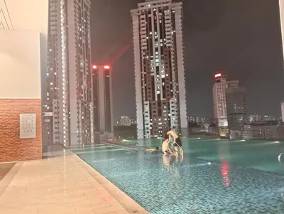 two people in a swimming pool with a city skyline at Chamber suites KLCC by Global stay in Kuala Lumpur