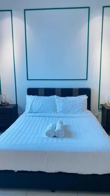 a pair of towels sitting on a bed at Chamber suites KLCC by Global stay in Kuala Lumpur