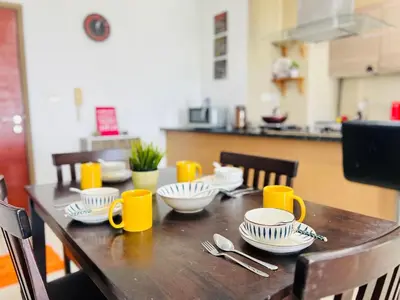 a wooden table with plates and cups and utensils on it at 231TR Service Suites by DeUrban in Kuala Lumpur