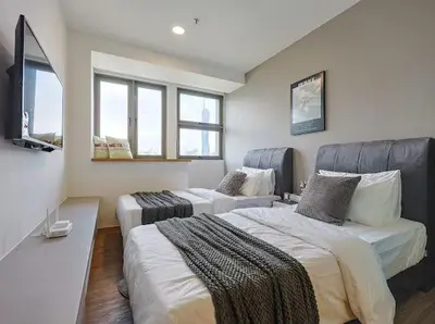a bedroom with two beds and a flat screen tv at KL Sentral city retreats with KLCC views in Kuala Lumpur
