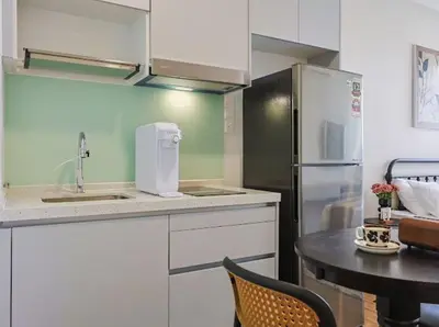 a kitchen with a sink and a refrigerator and a table at KL Sentral city retreats with KLCC views in Kuala Lumpur