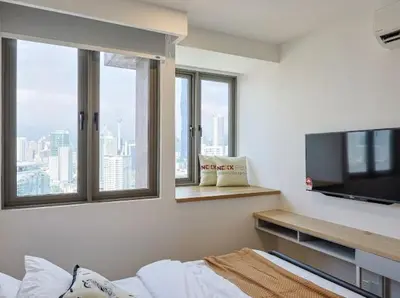 a bedroom with a flat screen tv and windows at KL Sentral city retreats with KLCC views in Kuala Lumpur