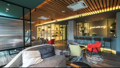a lobby with a couch and chairs and a bar at Ceylonz Suites KLCC by WSD in Kuala Lumpur