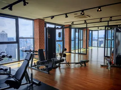 a gym with exercise equipment in a building with windows at Ceylonz Suites KLCC by WSD in Kuala Lumpur