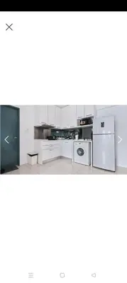 a kitchen with white cabinets and a refrigerator at Summer Suites By SmartWill in Gua Sai