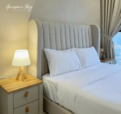 a bedroom with a bed and a lamp on a night stand at Trion KL By The Relaxstay in Kuala Lumpur