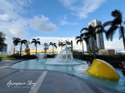 a water slide in a park with palm trees at Trion KL By The Relaxstay in Kuala Lumpur