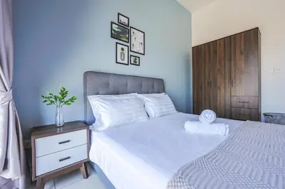 a bedroom with a bed and a nightstand with a white bedspread at Trion Kuala Lumpur by Vivid Stay in Kuala Lumpur
