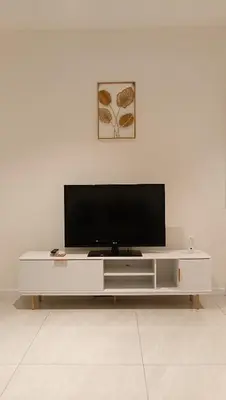 a white entertainment center with a flat screen tv on it at Quill Residence- Minimalist Urban Condo by Azmila in Kuala Lumpur