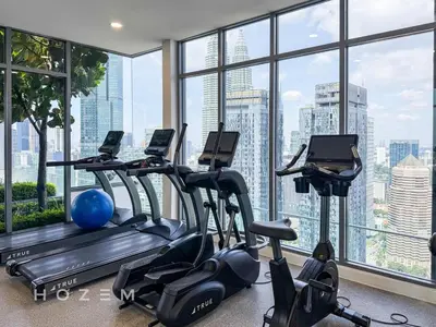 a gym with cardio machines and a large window at 2BR2B Hozem KL3802 Apartment KLCC in Kuala Lumpur