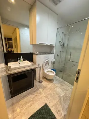 a bathroom with a toilet and a sink and a shower at The Platinum Suites KLCC in Kuala Lumpur