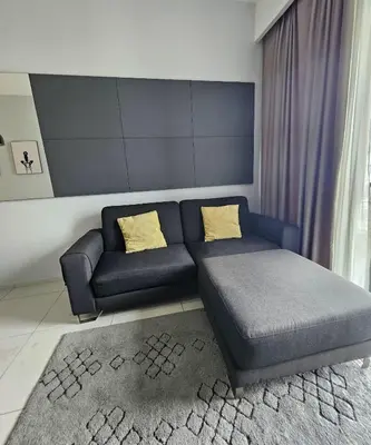 a living room with a blue couch and yellow pillows at The Signature Suites at Robertson Bukit Bintang in Kuala Lumpur