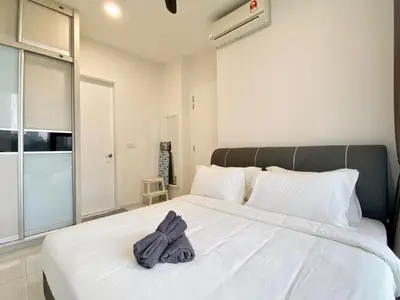 a bedroom with a white bed with towels on it at The Loft Living Suites at Robertson Residences in Kuala Lumpur
