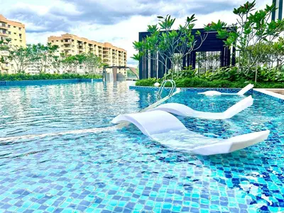 a swimming pool with two white chairs in the water at KL Central 32 Floor KLCC View in Kuala Lumpur
